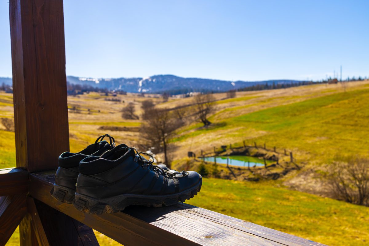 Wanderschuhe vor Berghintergrund auf Balkon zum Lüften