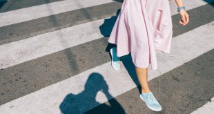 Junge Frau in pinkem Rock und Sneakern