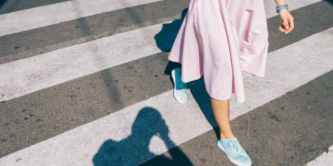 Junge Frau in pinkem Rock und Sneakern