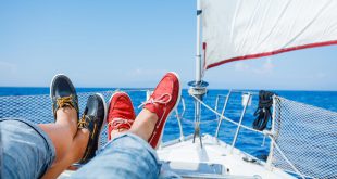 2 Menschen mit Bootsschuhen liegen auf Segelboot