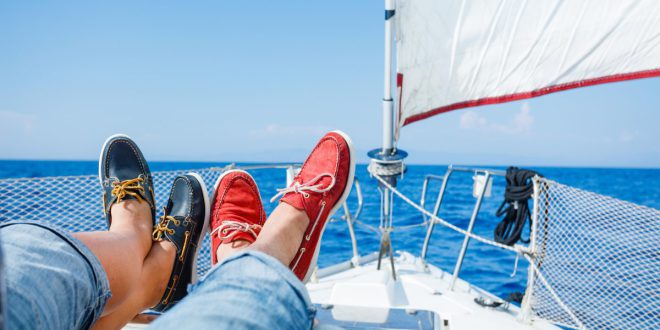 2 Menschen mit Bootsschuhen liegen auf Segelboot