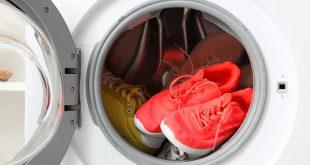 Mehrere Paare Schuhe in offener Waschmaschine, rotes Paar im Fokus