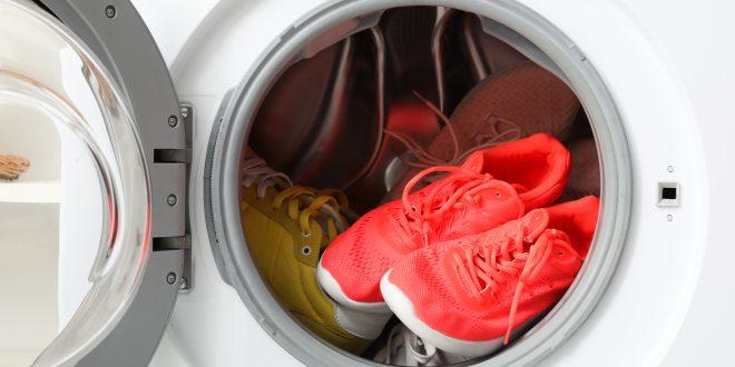 Mehrere Paare Schuhe in offener Waschmaschine, rotes Paar im Fokus